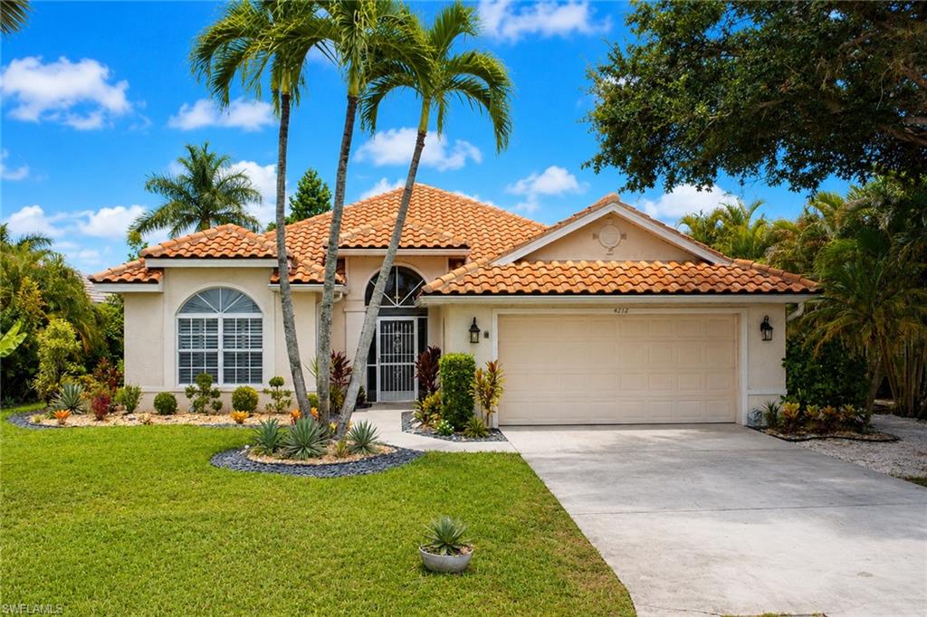 Mediterranean-style architecture with a tile roof, arched entryway, and an attached two-car garage