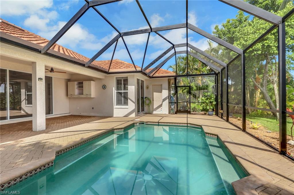 Screened lanai featuring a swimming pool, covered patio, and outdoor cabinetry
