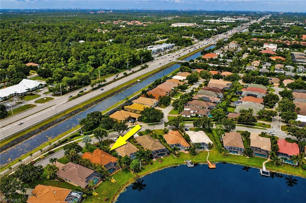 Waterfront property with private dock, featuring a lush green lawn and mature landscaping