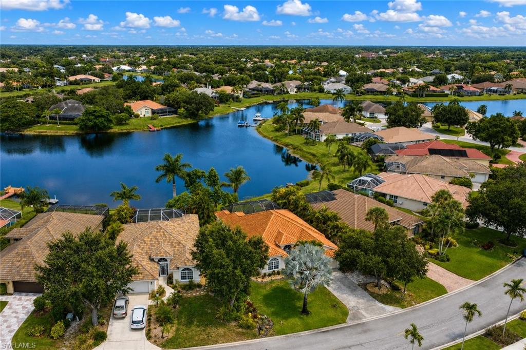 Expansive waterway, lush green landscaping, mature palm trees, residential neighborhood