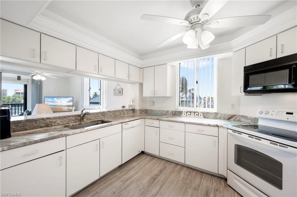 Kitchen featuring ceiling fan, white appliances, white cabinetry, and plenty of natural light