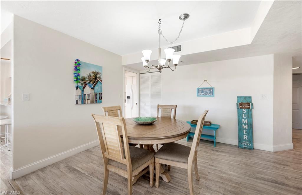 Dining room with light wood-style flooring and a chandelier