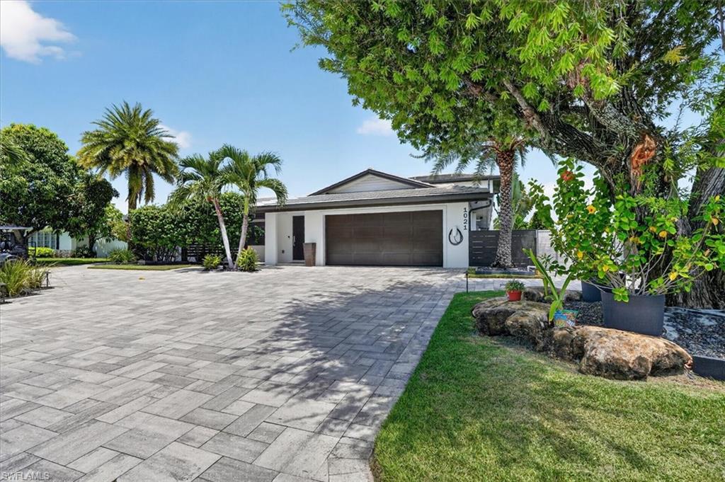 Impact rated garage door, flat tile roof, paver circular drive