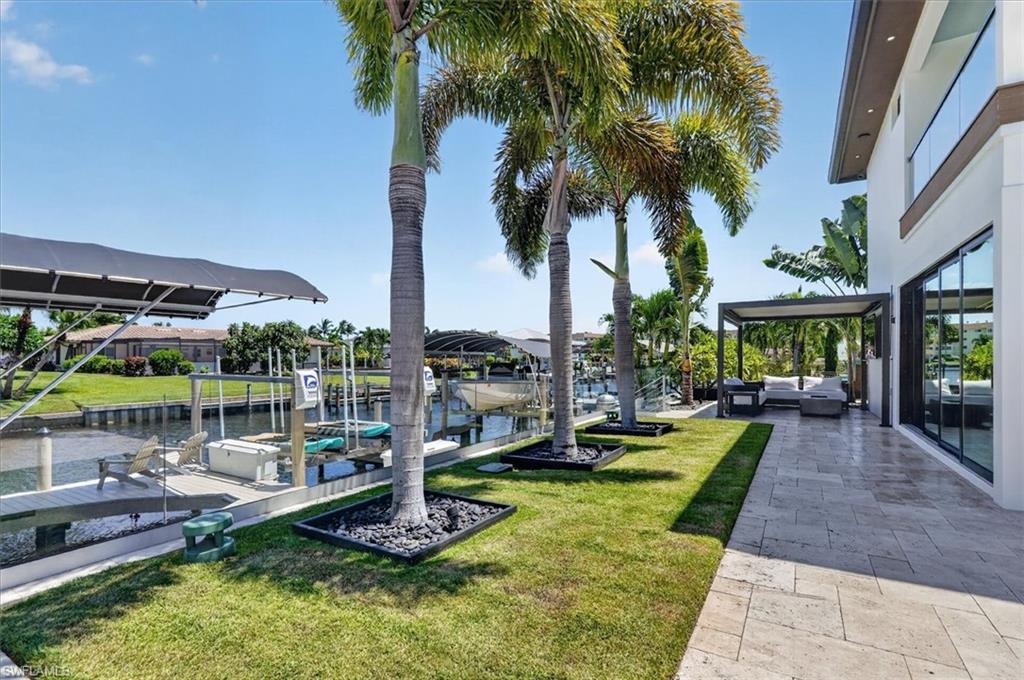 Pavered area with covered seating area and stairs leading to the dock.