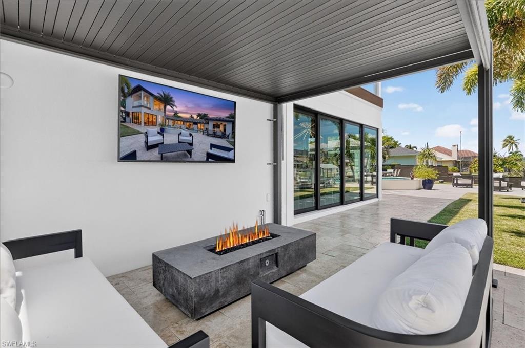 2nd covered patio with built in firepit & TV near the outdoor kitchen