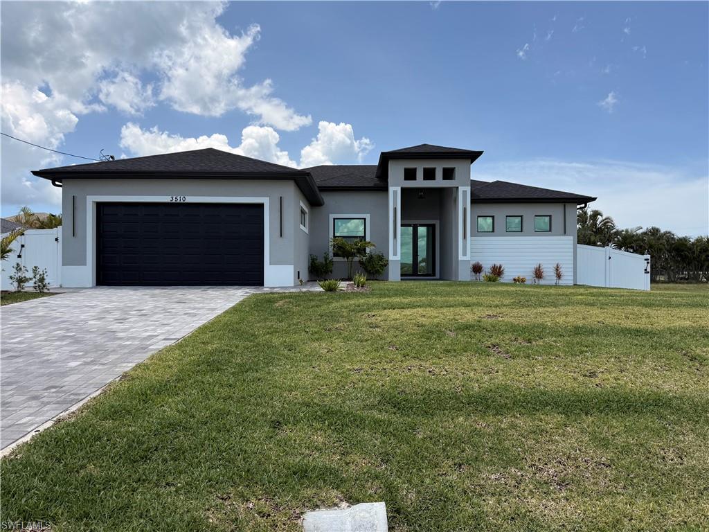 Contemporary single-story residence with a dark roof and light gray exterior