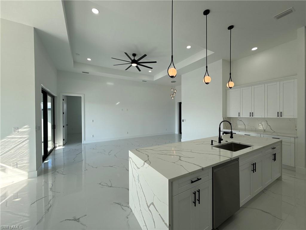 Spacious interior with high ceilings, recessed lighting, and large format white tile flooring