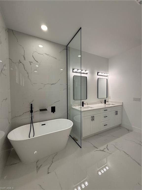 Freestanding soaking tub with matte black fixtures, dual vanity with white cabinetry, polished countertops, and large format tiled flooring