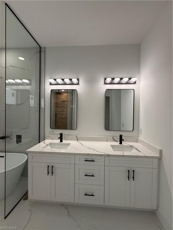 Dual vanity with white cabinetry and black hardware, quartz countertops, undermount sinks, and wall-mounted light fixtures