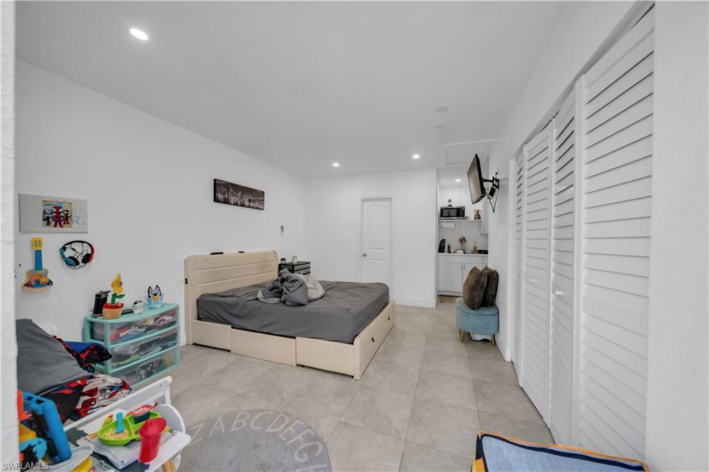 Recessed lighting, tile flooring, louvered closet doors, and built-in kitchenette
