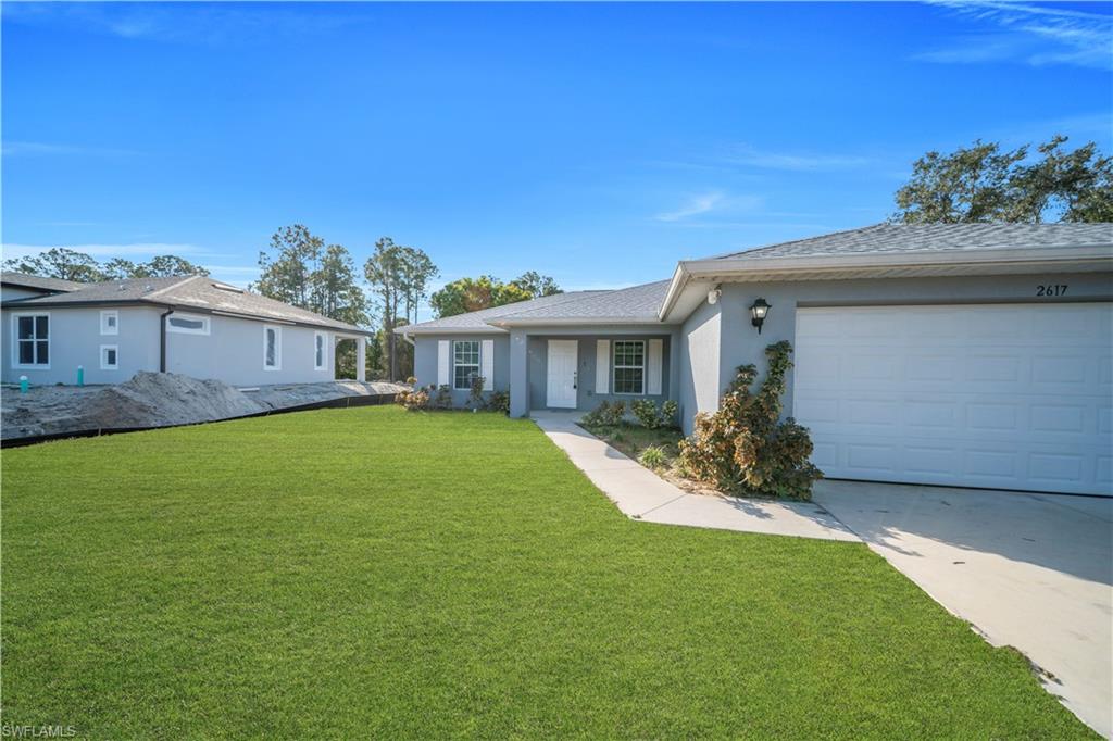 Exterior features a gray stucco finish, white garage door, and a well-maintained lawn
