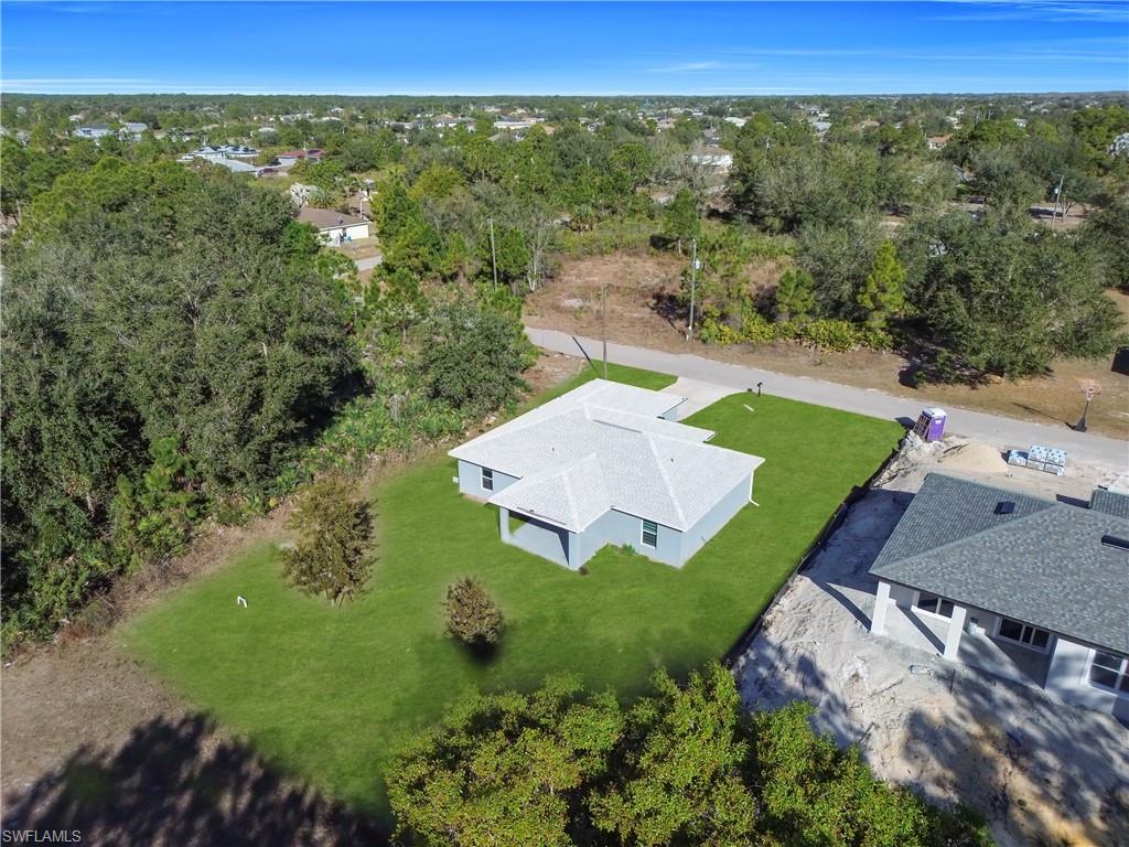 Single-story residence featuring a light gray exterior, a gray shingle roof, and a green lawn