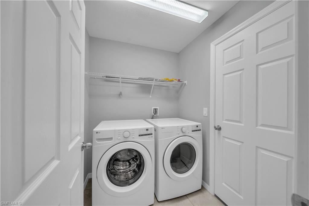 Laundry area with a wire shelf, tile flooring, and overhead lighting