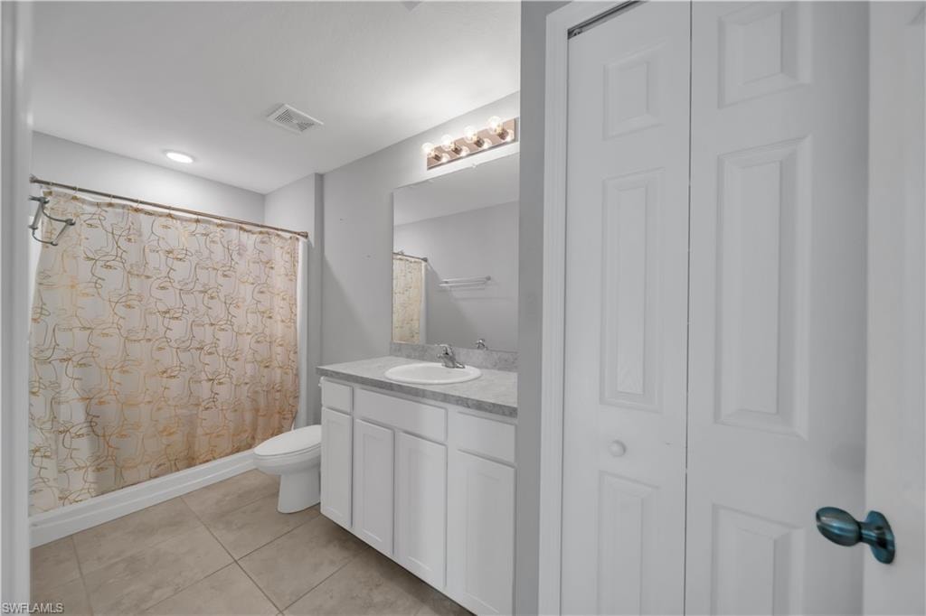 Bathroom featuring a white vanity with integrated sink, light-colored countertop, and a shower/tub combination