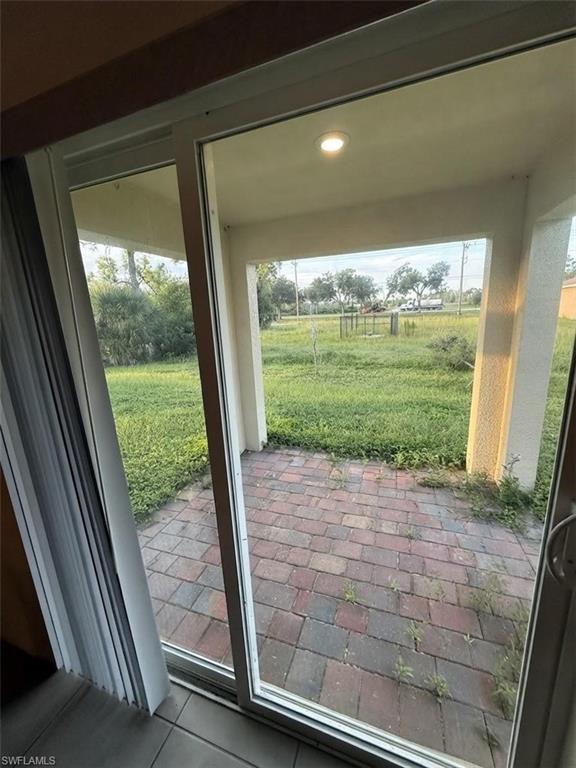 Sliding glass door leading to a covered patio with recessed lighting
