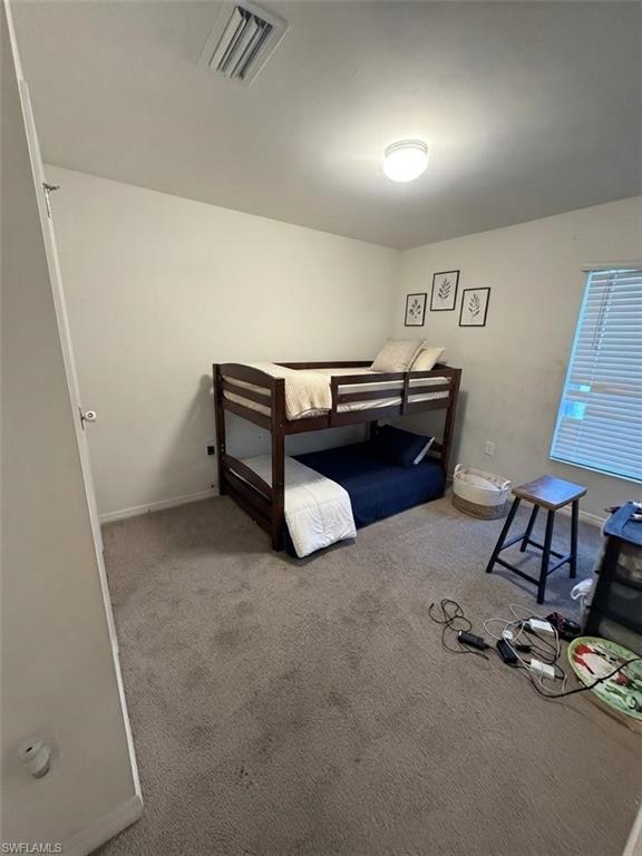 Recessed ceiling light, wall-to-wall carpeting, and window with horizontal blinds