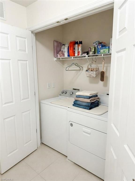 Dedicated laundry closet featuring a built-in wire shelf, a top-load washing machine, and a front-load dryer