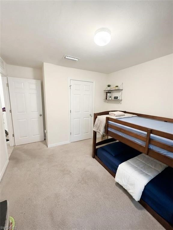 Neutral tone wall finishes, flush mount ceiling lighting, and carpeted flooring