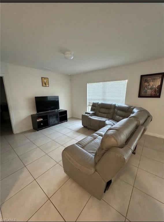 Tiled flooring and white walls with a window featuring horizontal blinds