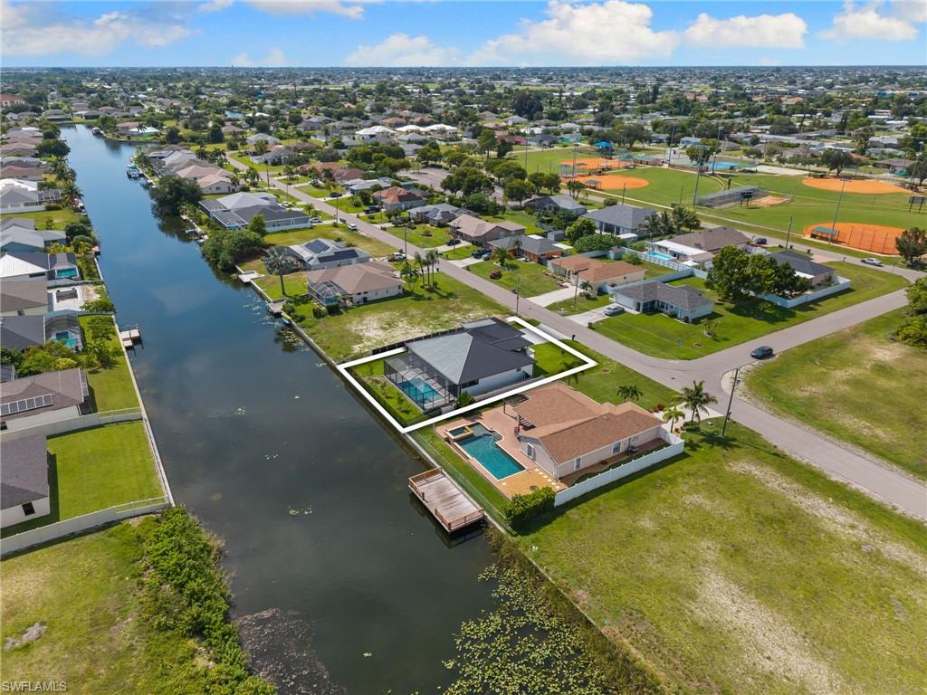 Waterfront property with a private screened swimming pool, mature palms, and direct canal access