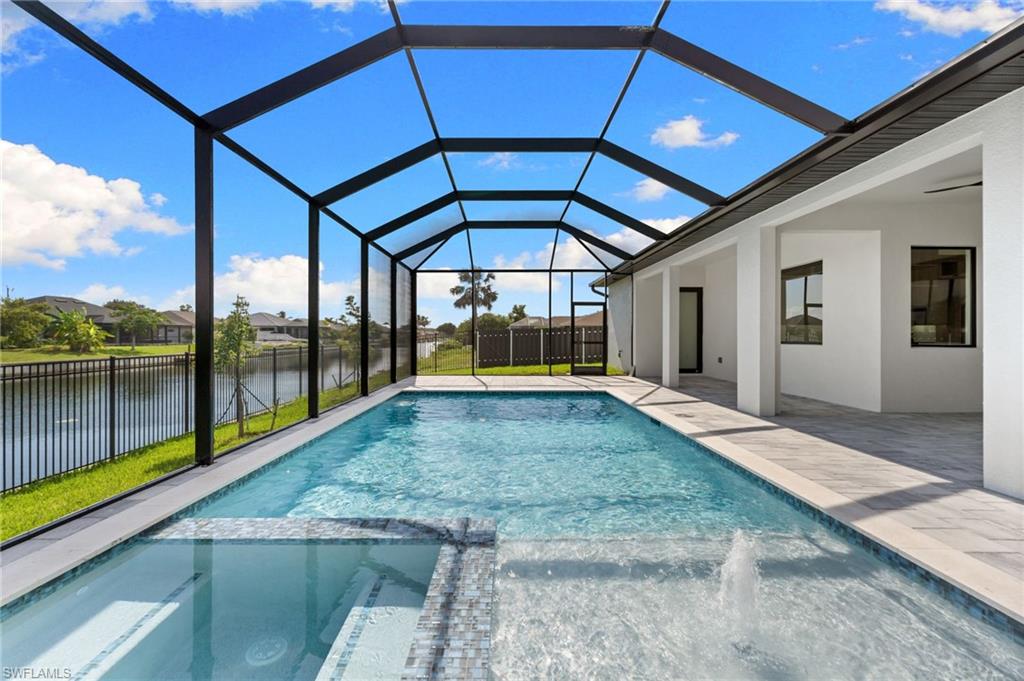 Screened lanai featuring a swimming pool, integrated spa with mosaic tile, and a water feature