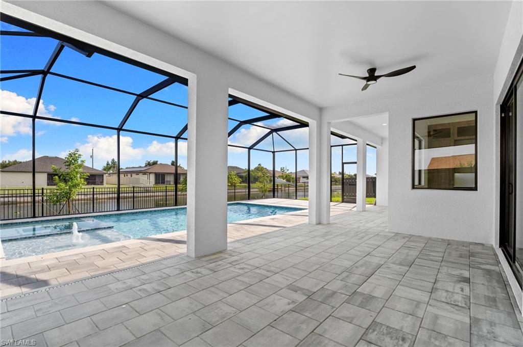 Expansive screened lanai with a swimming pool, integrated spa, and paved flooring