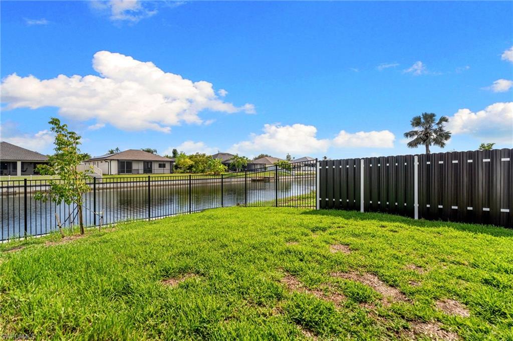 Expansive green space with a water feature and partial privacy fencing
