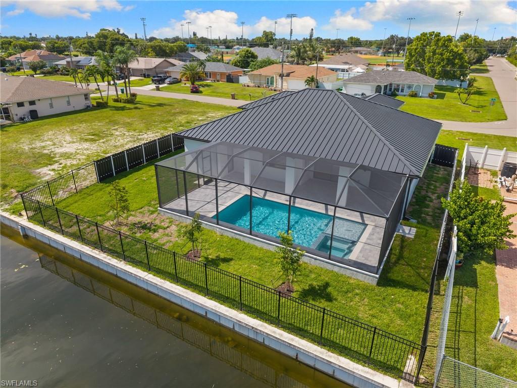 Screened-in swimming pool and spa with a concrete paver deck
