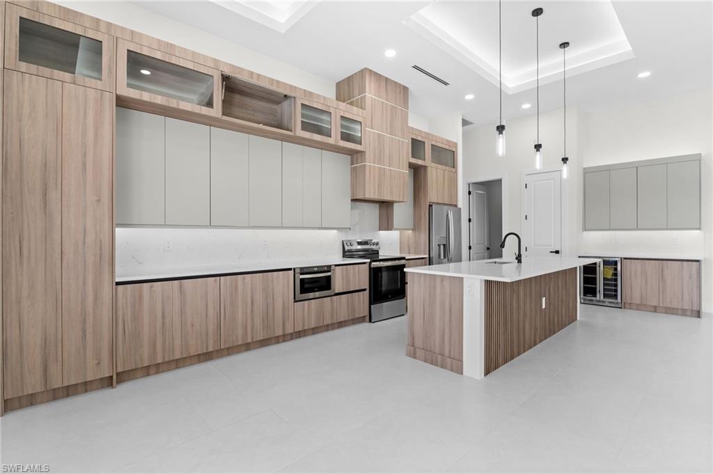 Expansive kitchen featuring a center island, integrated appliances, wood-finish cabinetry, and recessed lighting