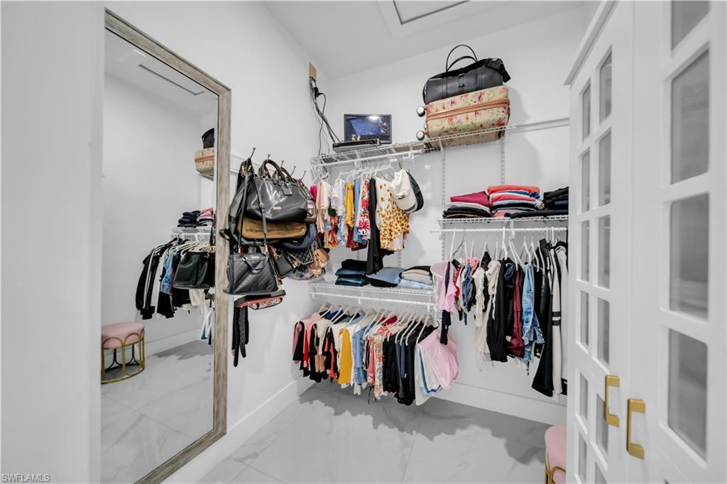 Custom closet system with white shelving and hanging rods