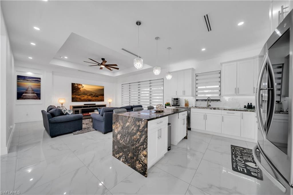Open-concept layout featuring large format tile flooring and recessed lighting