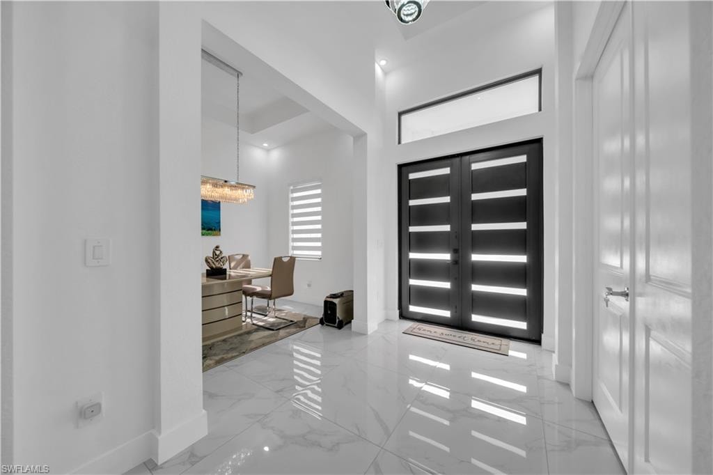 Double entry doors with frosted glass panels, transom window, and high ceilings