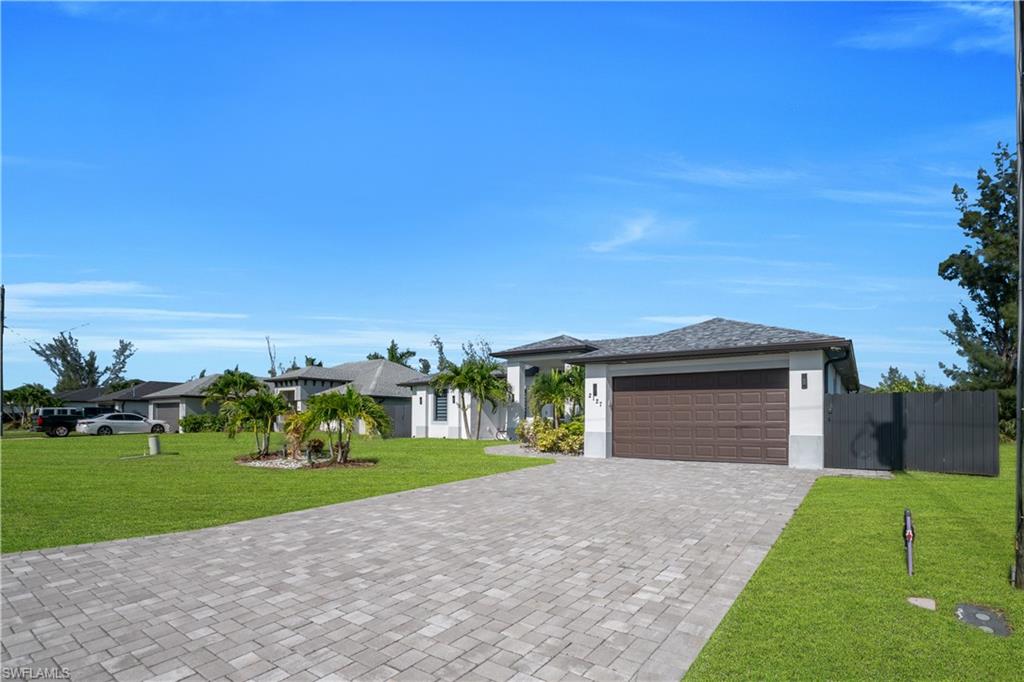 Paver driveway leading to a two-car garage with a brown door