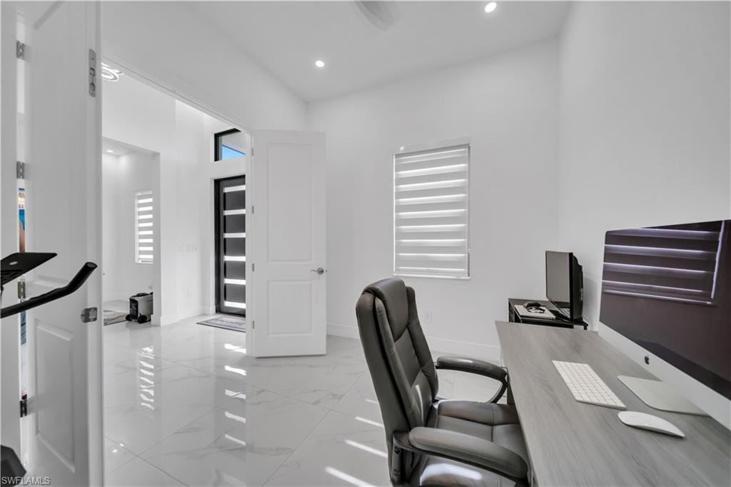 Tile flooring throughout, recessed lighting, and a modern entry door with a transom window