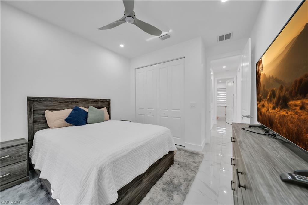 Recessed lighting, ceiling fan, white paneled bifold closet doors, and light-toned tile flooring