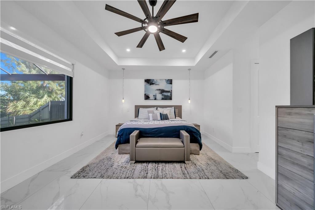Tray ceiling with recessed lighting and a ceiling fan, large window with integrated blinds, pendant lighting, and tile flooring