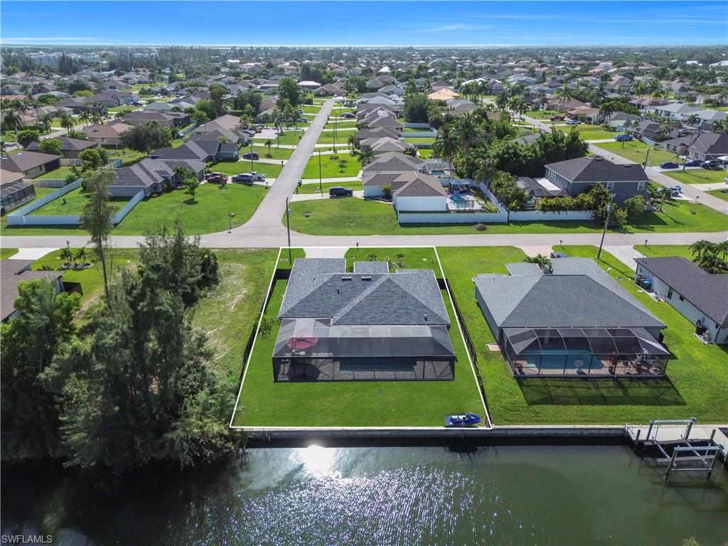 Waterfront property featuring a screened-in pool and an adjacent boat dock