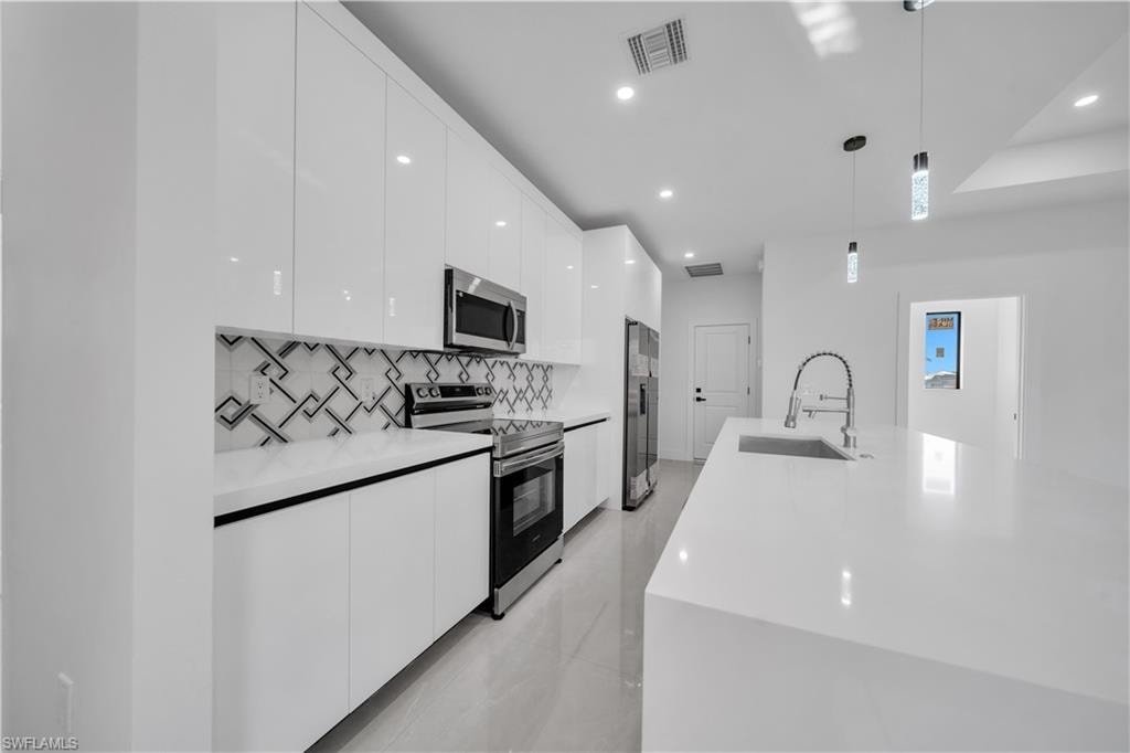 Modern kitchen featuring a large island with sink, white countertops, and wood-finish paneling