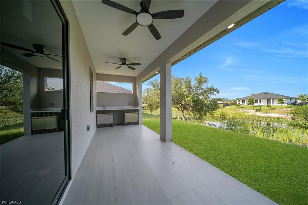 Outdoor kitchen featuring a built-in sink with faucet, stainless steel cabinetry, and a light-toned countertop