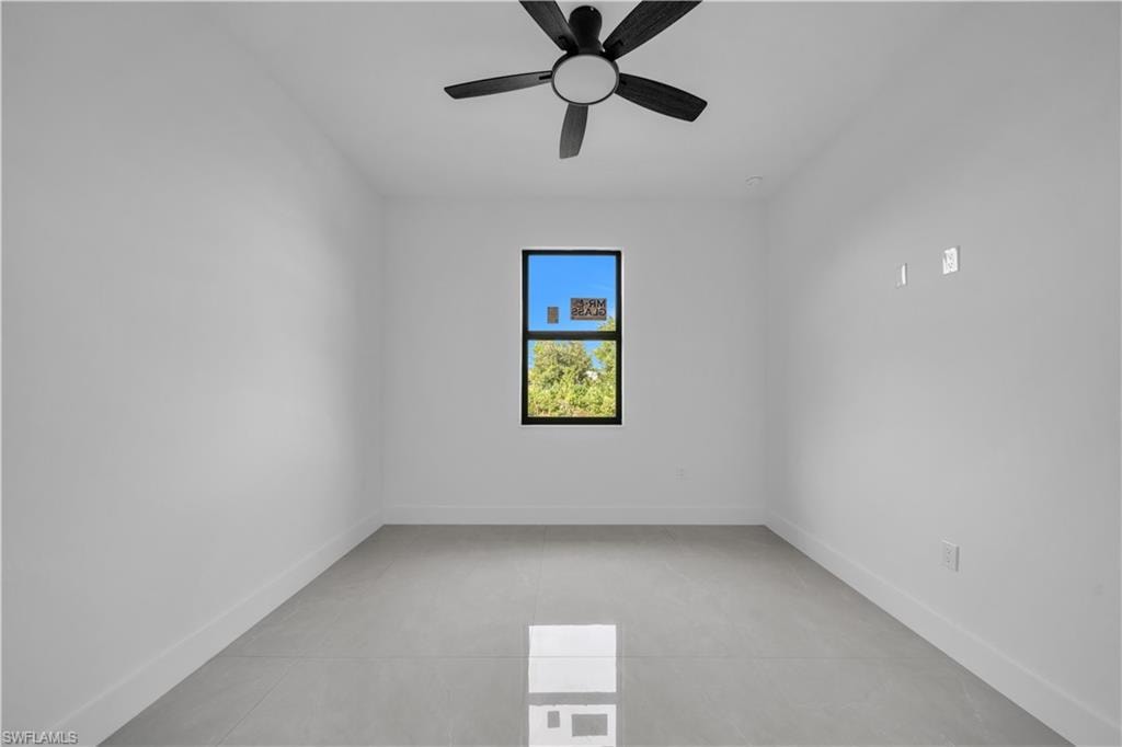Recessed lighting, contemporary chandelier, large windows with black trim, light-toned tile flooring, and white painted walls