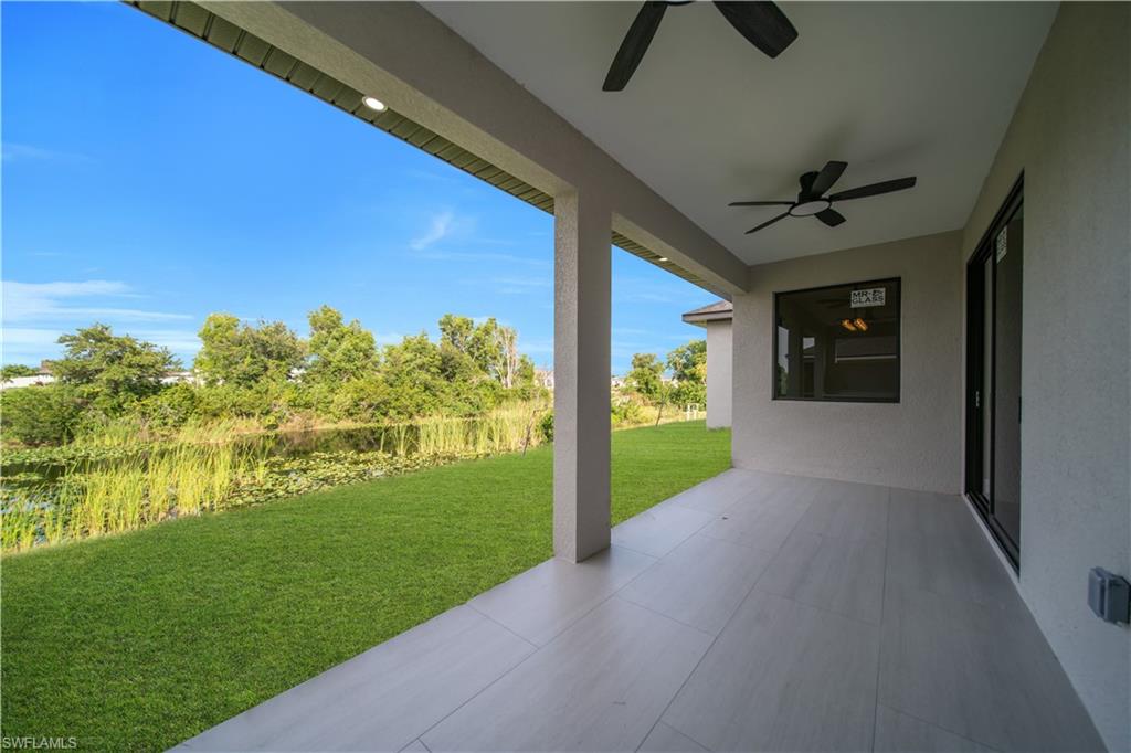 Covered patio with recessed lighting, integrated ceiling fans, and an outdoor kitchen featuring built-in cabinetry and a sink
