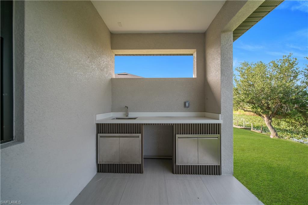 Glass-enclosed shower with geometric-patterned tile, matte black shower fixtures, and a sleek linear drain