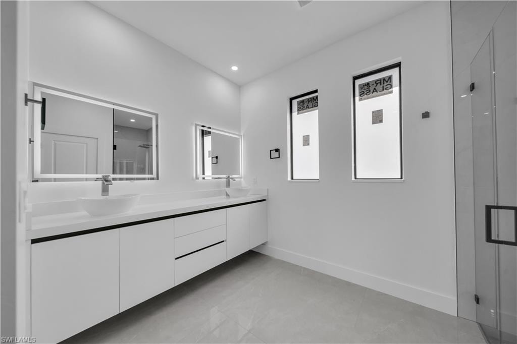 Walk-in shower with clear glass enclosure and black hardware