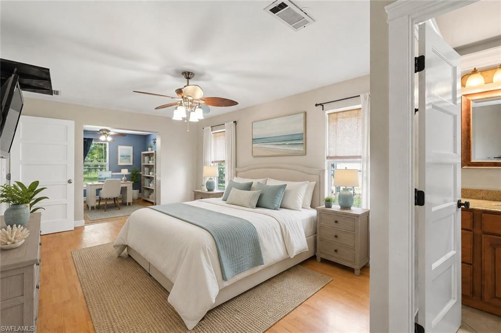 Spacious bedroom featuring wood-finish flooring, ceiling fan, and access to a private study