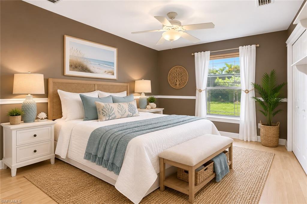 Light wood-finish flooring, a ceiling fan with integrated lighting, and a window with white trim