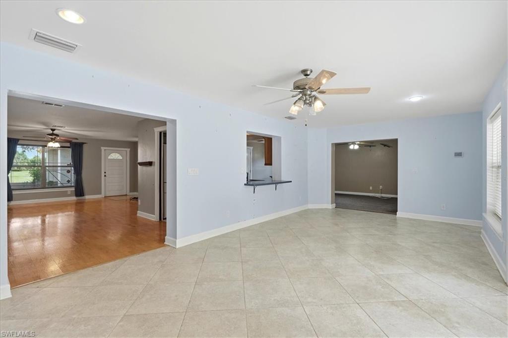 Tile flooring, recessed lighting, ceiling fan, pass-through window, and window with blinds