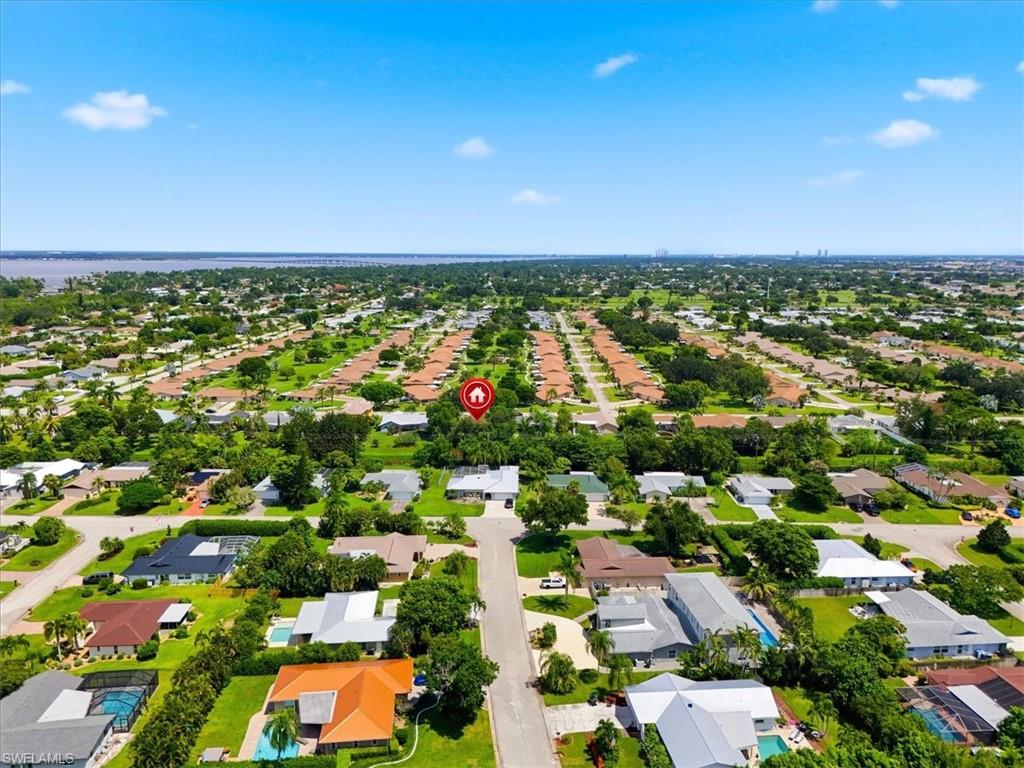 Aerial perspective showcasing a residential area with mature trees, established properties, and a prominent waterway in the background