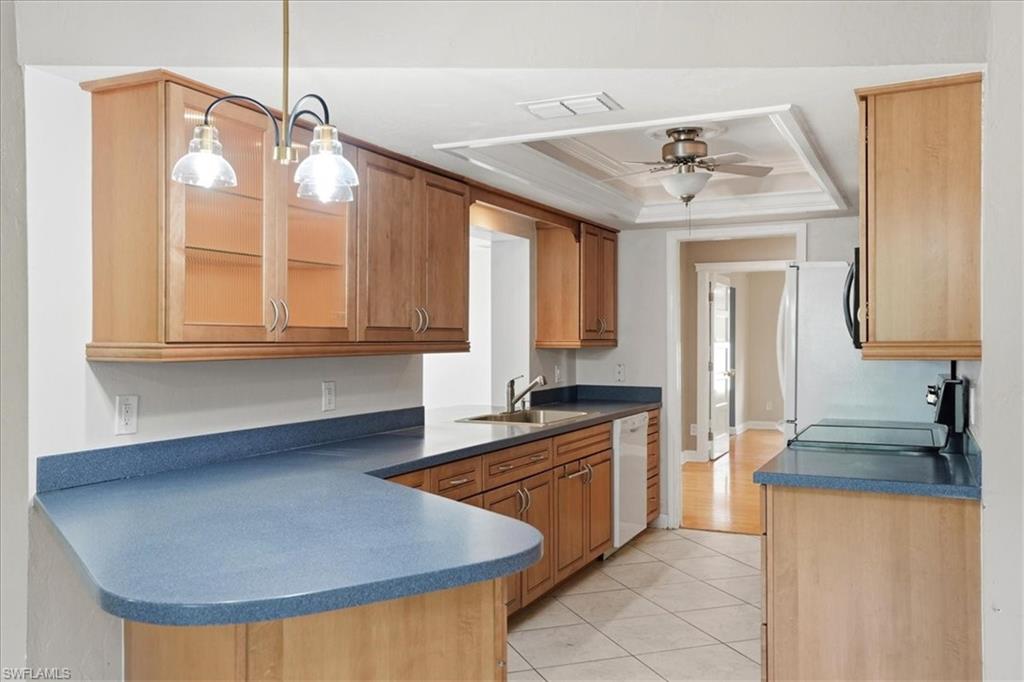 Kitchen with wood-finish cabinetry, blue countertops, and white tile flooring
