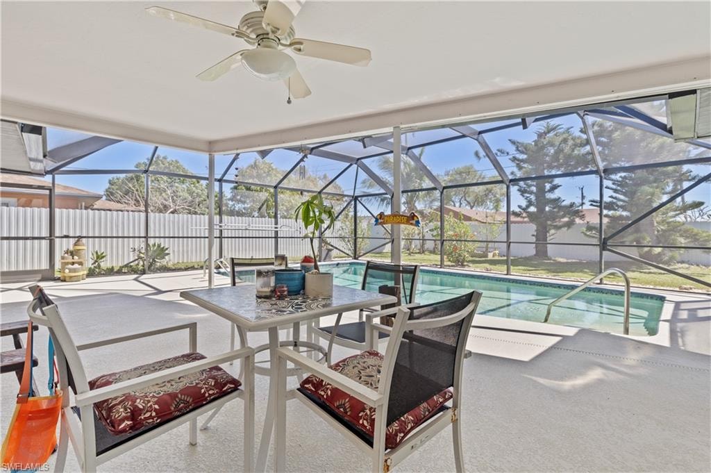 View of pool with ceiling fan, a patio area, fence, and a lanai