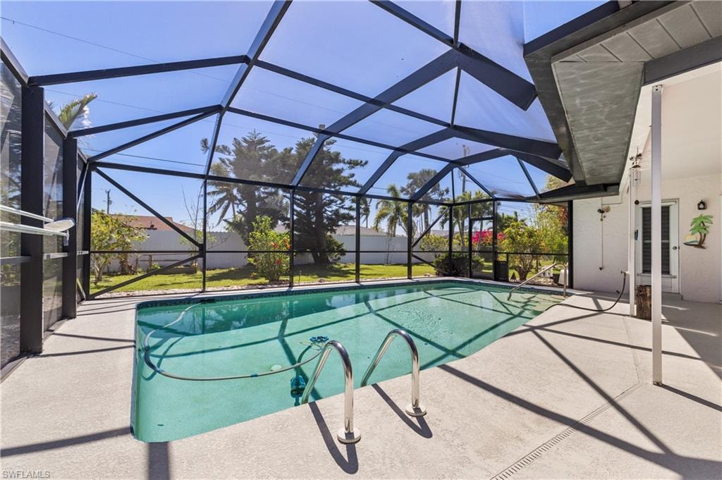 View of swimming pool with a fenced in pool, glass enclosure, and a patio area